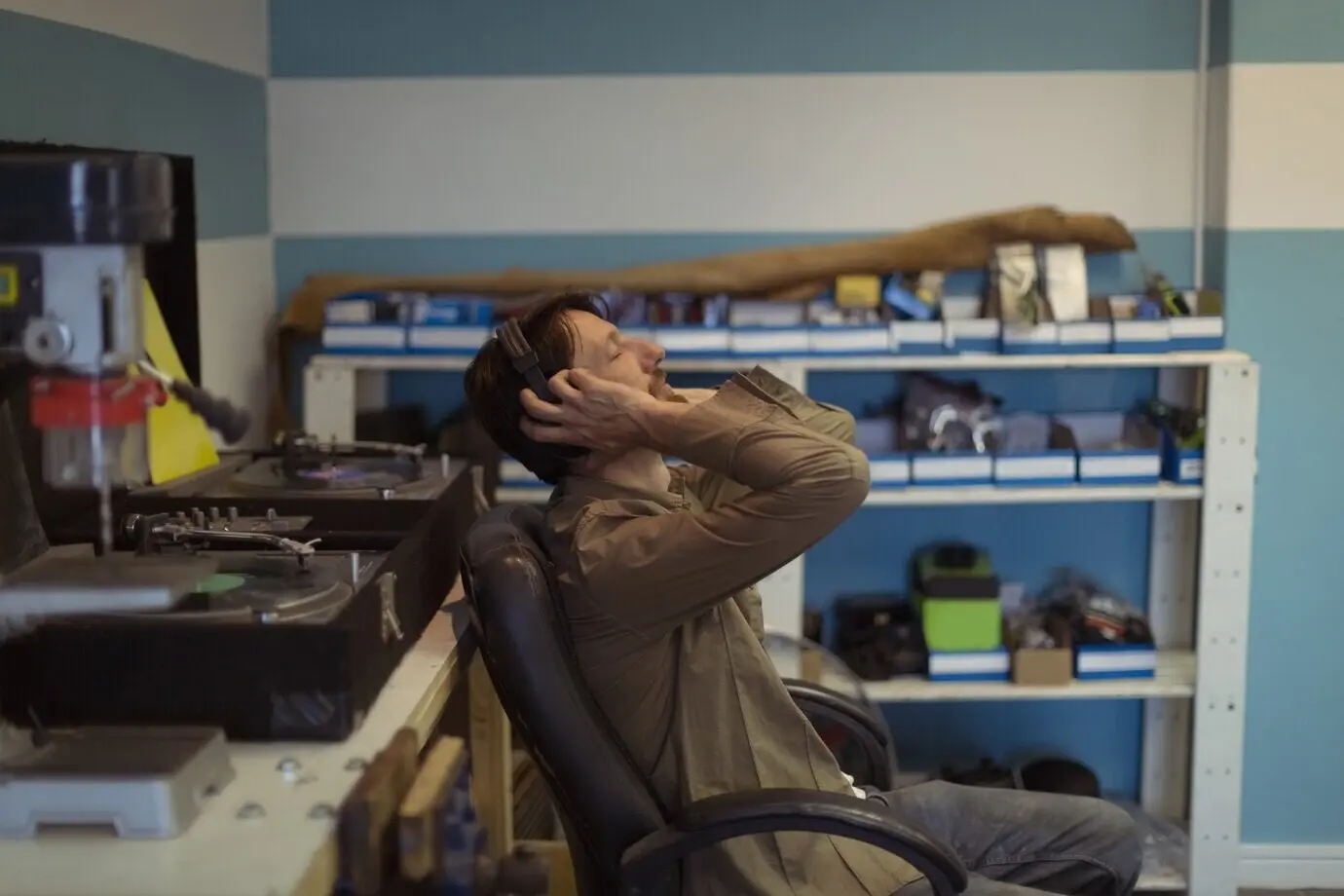 Die Besitzerin oder der Besitzer hört in einer Fahrradwerkstatt mit geschlossenen Augen Musik.